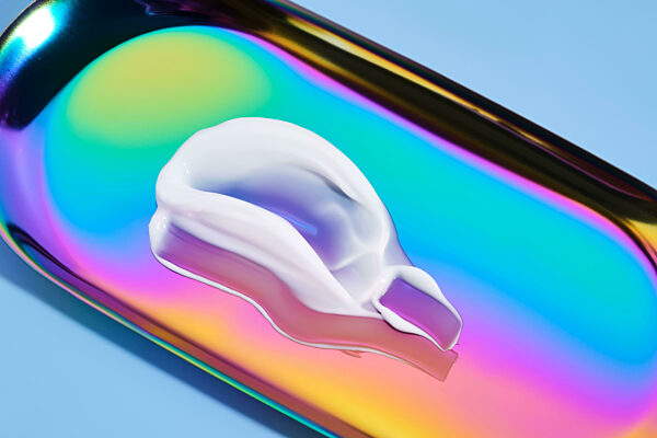 Die Textur von weißer Creme auf einem mehrfarbigen Hintergrund.