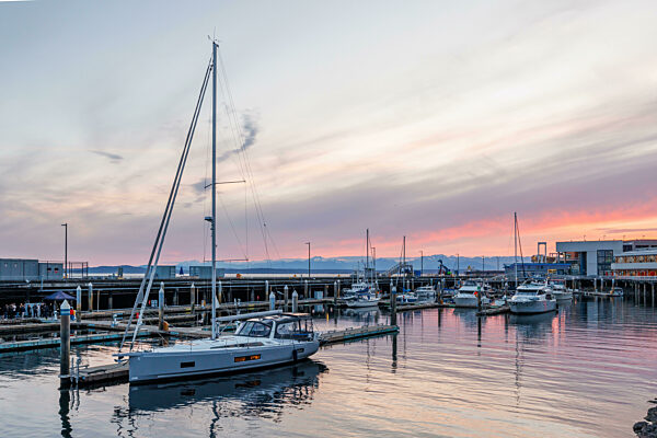 Hafen von Seattle bei Sonnenuntergang mit ruhigem Wasser und Silhouetten von Booten