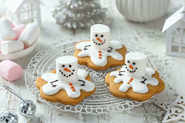 Süß und lustig schmelzenden Marshmallow Schneemann Cookies. Weihnachten und Neujahr Dessert und Dekoration Idee für den Urlaub. Weißer Hintergrund