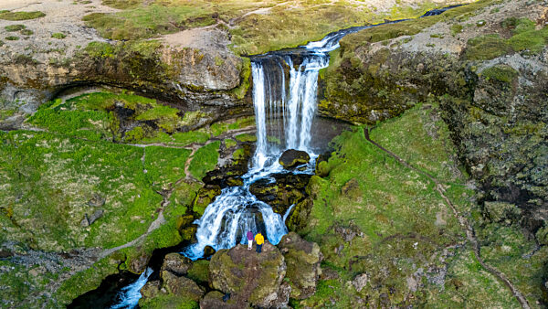 Selvallafoss Wasserfall fließt anmutig in ein felsiges Becken umgeben von lebendigen grünen Moos und robustem Gelände von Island