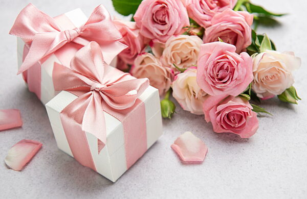 Zarte rosa Rosen und Geschenkboxen zu einem besonderen Anlass
