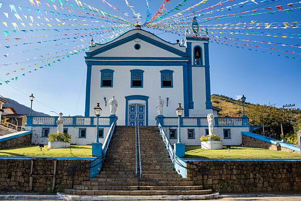 Die Kirche Our Lady Help Of ist mit bunten Festtagsfahnen vor blauem Himmel geschmückt. Ilhabela, Sao Paulo Brasilien.