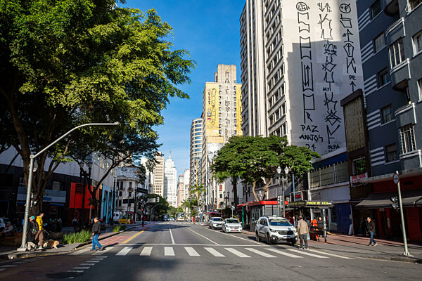 Stadtlandschaft von Sao Paulo, die den Kontrast zwischen historischen und modernen Gebäuden entlang einer stark befahrenen Straße zeigt. Brasilien
