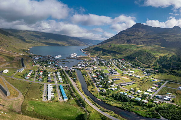 Luftaufnahme von Seydisfjordur und Kreuzfahrtschiffen im Hafen im Fjord