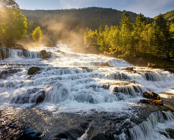 Blick auf den breiten Wasserfall Vallestadfossen im Südwesten Norwegens im goldenen Morgenlicht