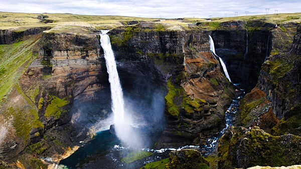 Majestätischer Haifoss-Wasserfall, der von schroffen Klippen in Islands atemberaubender Landschaft herabstürzt