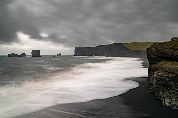 Blick auf die schwarzen Sandstrände und zerklüfteten Klippen der südisländischen Küste bei Dyrholaey