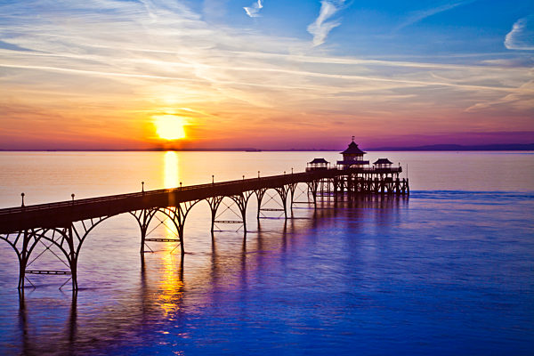 The sun sets over the Bristol Channel behind the pier at Clevedon in Somerset.