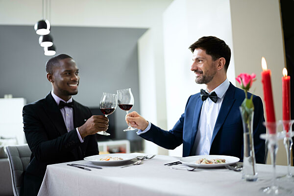 Gay Couple Having Dinner In Restaurant