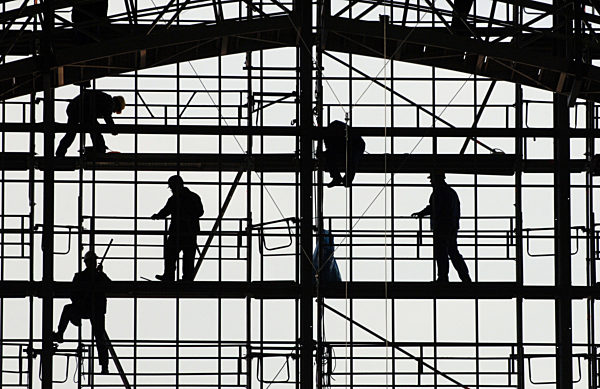 Wie ein Scherenschnitt wirken Arbeiter, die am Sonntag (22.05...