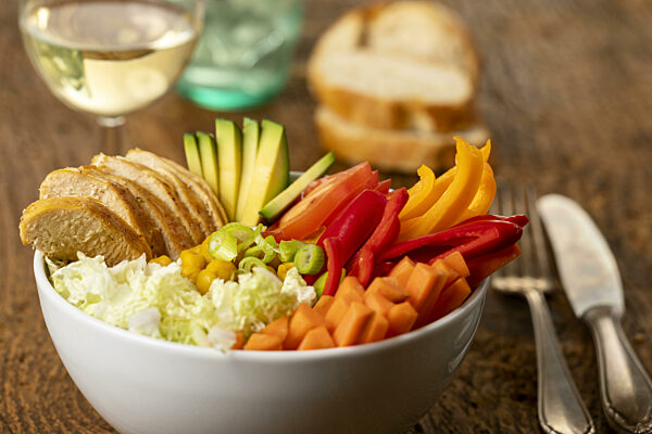 Buddha Bowl mit Hühnchen auf Holz