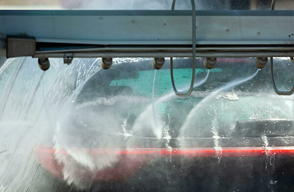Fahrzeug wird in einer Waschanlage mit Wassersprühstrahl gereinigt