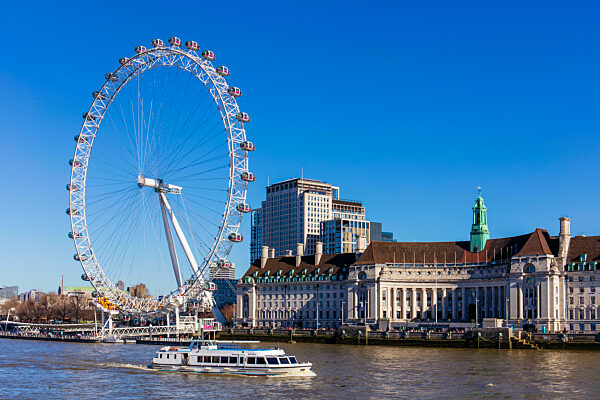 A boat passing in front of the London Eye and London Aquarium on a sunny day, London, England, United Kingdom, Europe