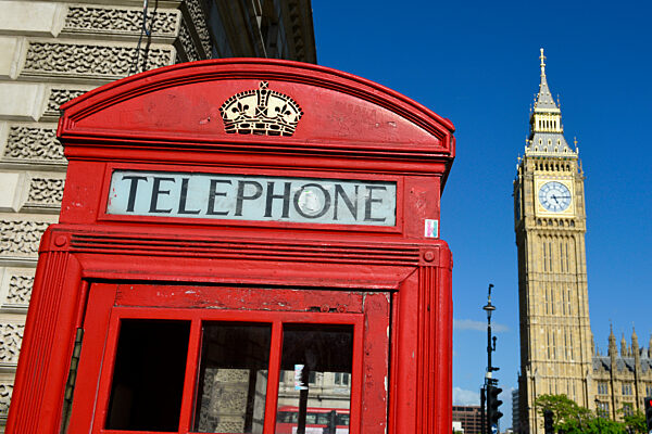 Iconic red telephone box with Big Ben (Elizabeth Tower) in background. London - England