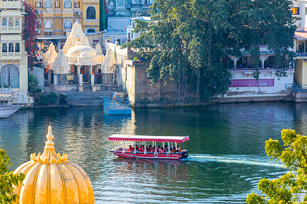 Tourist Boat on Lake Pichola with the City Palace in the background, Udaipur, Rajasthan, India, South Asia.
