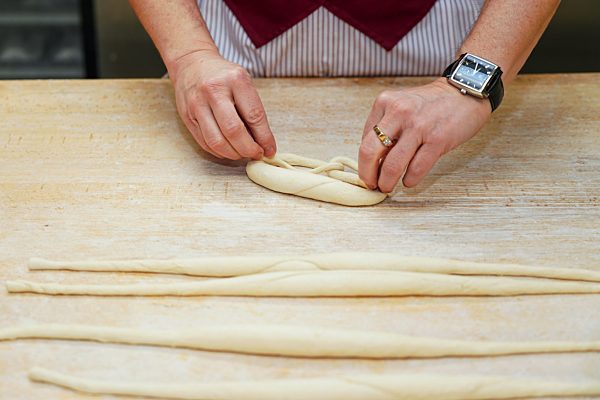 Die schwaebische Laugenbrezel entsteht aus einem Teigstrang. Zum Schlingen von Brezeln verwenden Baecker eine spezielle Wurftechnik. Einer Legende nach, wurde die Brezel von einem Baecker aus Bad Urach (Baden Wuerttemberg) erfunden.