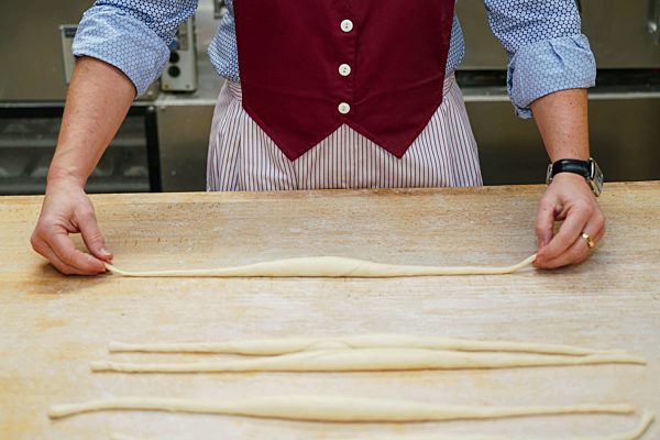 Die schwaebische Laugenbrezel entsteht aus einem Teigstrang. Zum Schlingen von Brezeln verwenden Baecker eine spezielle Wurftechnik. Einer Legende nach, wurde die Brezel von einem Baecker aus Bad Urach (Baden Wuerttemberg) erfunden.