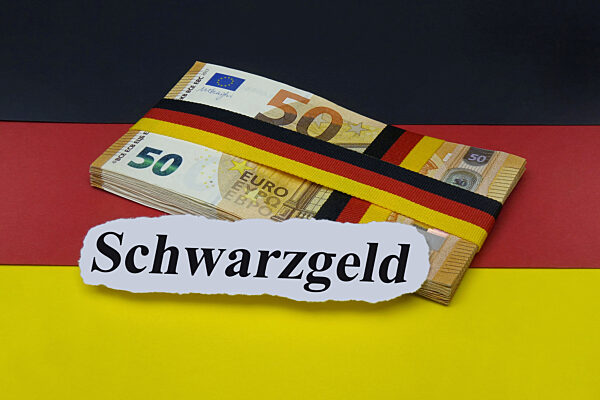 Deutschlandfahne mit Geldscheinbuendel und Schwarzgeld