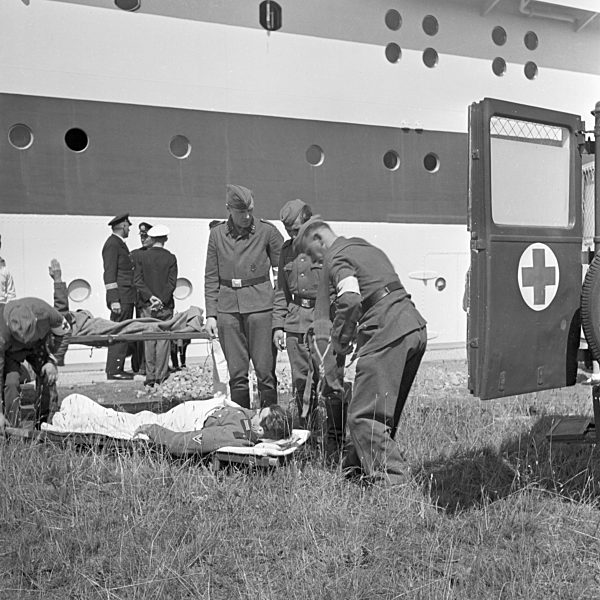 Original-Bildunterschrift: Verladung der Verwundeten vom Schiff "Wilhelm Gustloff" in Sanitätswagen; Deutschland 1940er Jahre. Wounded soldiers being brought to ambulances after leaving the ship "Wilhelm Gustloff"; Germany 1940s.