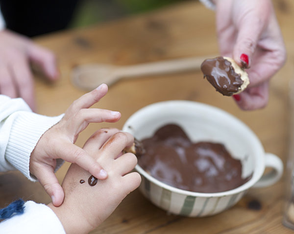 Frau; Kind; Plätzchen backen; eintauchen in Schokolade; Nahaufnahme; Detail;