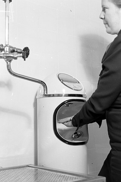 Eine Frau testet einen automatischen Händetrockner; Deutschland 1930er Jahre. A woman is testing an automatic hand dryer; Germany 1930s.