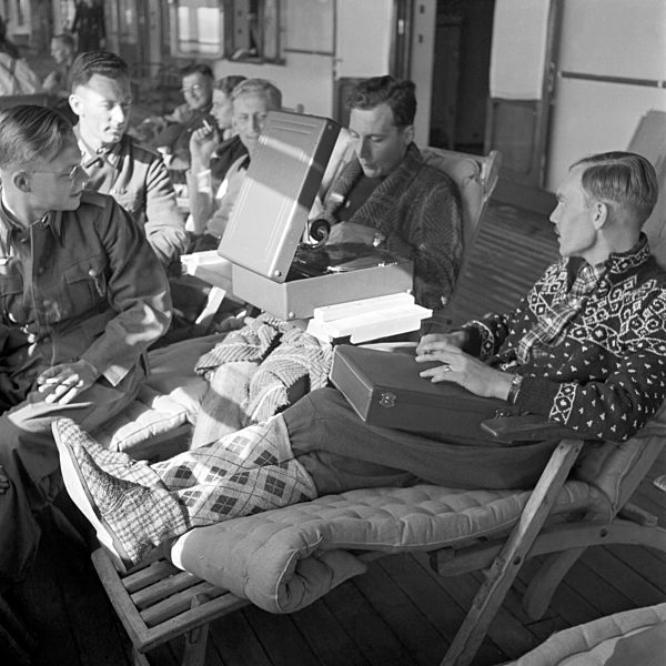 Original-Bildunterschrift: Lazarettschiff "Wilhelm Gustloff" - Eine Gruppe von Verwundeten auf dem Promenadendeck unterhält sich mit einem Grammophon; das eine Schwester ausgeliehen hat. Sie tragen zum Teil Pullover oder Strümpfe aus Norwegen. Hospital s