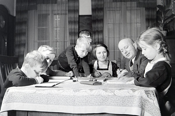 Mitglieder einer kinderreichen Familie bei den Hausaufgaben; Deutsches Reich 1930er Jahre. Members of a extended family doing the homework; Germany 1930s.