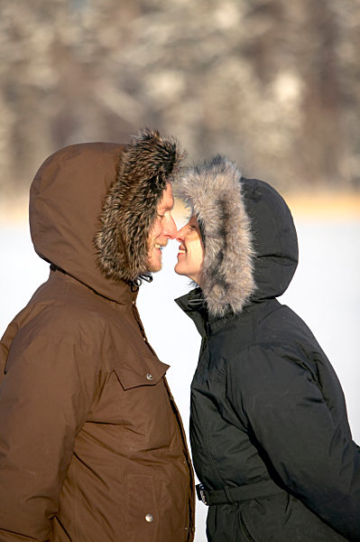 Lächelndes Paar reibt ihre Nasen im Winter