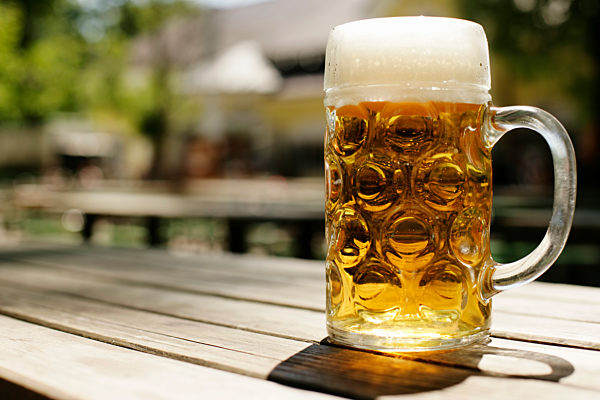Eine Maß Bier auf einem Holztisch - Sommer - Alkohol - Biergarten