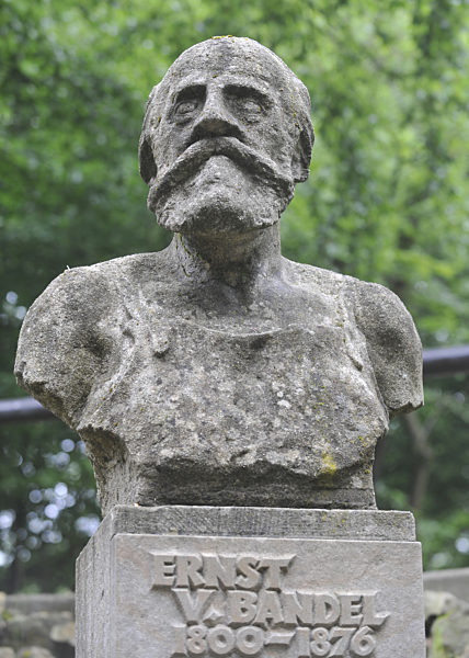Eine steinernde Büste erinnert am Fuße des Hermannsdenkmals in Detmold an...