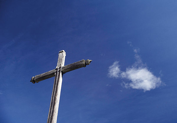 Holzkreuz vor blauem Himmel