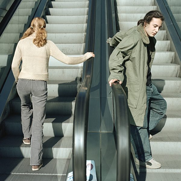 Young man and young woman on escalators