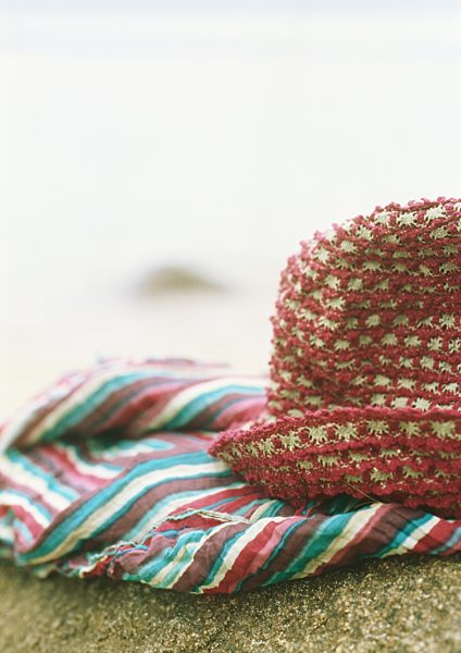 Sunhat and clothing on beach, close-up