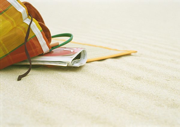 Beach bag and beach mat on beach