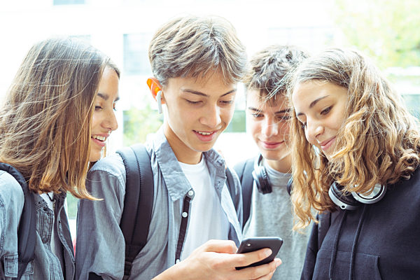 Friends using smartphone outdoors
