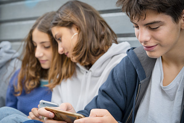 Friends using smartphone outdoors