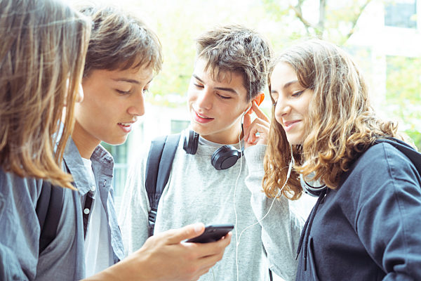 Friends using smartphone outdoors