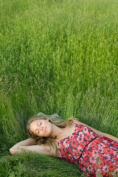 Young woman napping in tall grass