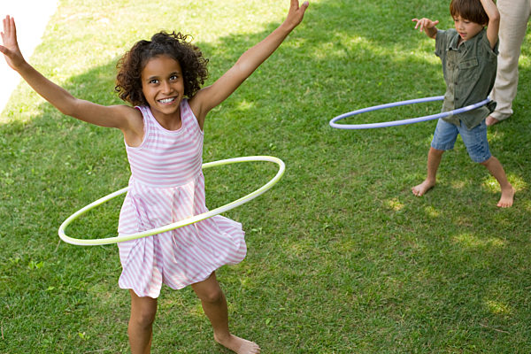 Children playing with plastic hoop outdoors