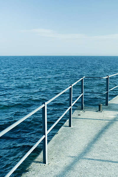 Concrete pier with metal railing on lake