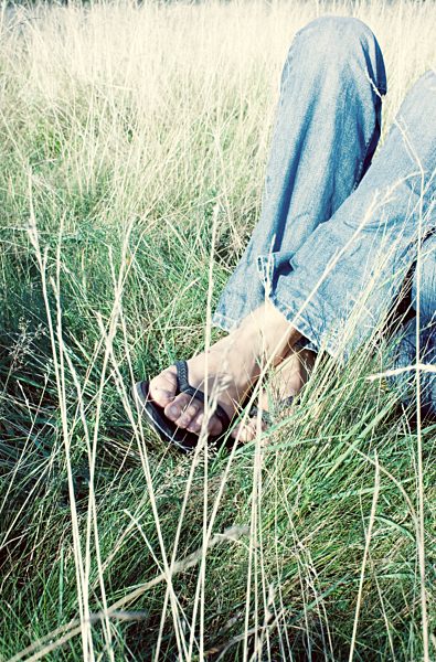 Man lying in tall grass, low section