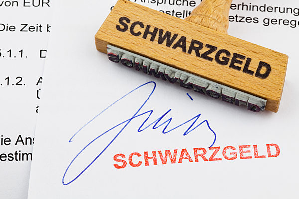 Holzstempel mit der Aufschrift: Schwarzgeld