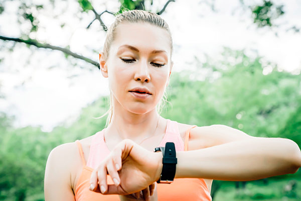 Caucasian woman checking the time on wristwatch outdoors, Kaukasische Frau, die Zeit auf Armbanduhr im Freien ueberProperty releaseuefung