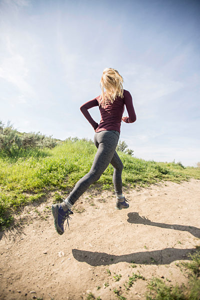 Caucasian woman running on dirt path, Kaukasische Frau auf Feldweg laeuft