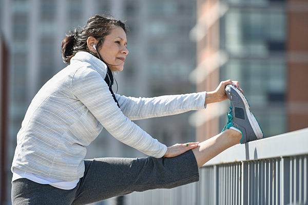 Hispanic woman stretching leg in city, Hispanic Frau Bein in der Stadt Reck