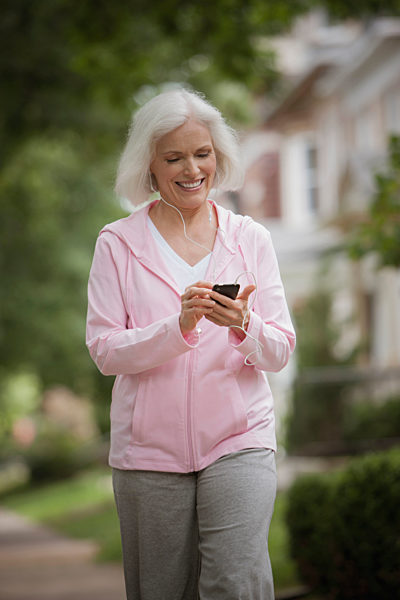 Caucasian woman walking and listening to mp3 player, Kaukasische Frau zu Fuss und MP3-Player hoeren