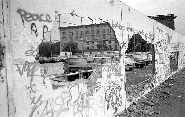 Durch einen von Löchern durchsetzten Mauerabschnitt fällt der Blick auf...