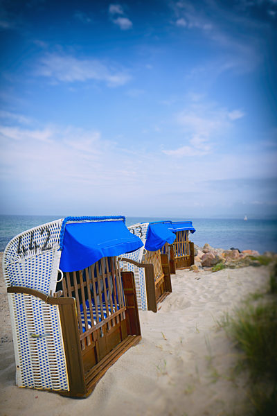 Row of hooded beach chairs ocean sea sand seaside