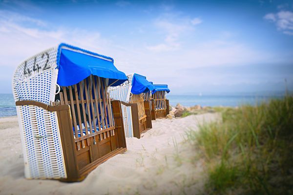 Row of hooded beach chairs ocean sea sand seaside