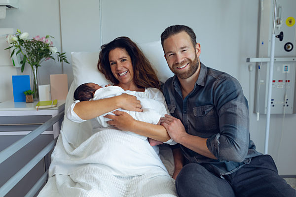 Couple holding their newborn baby in the ward